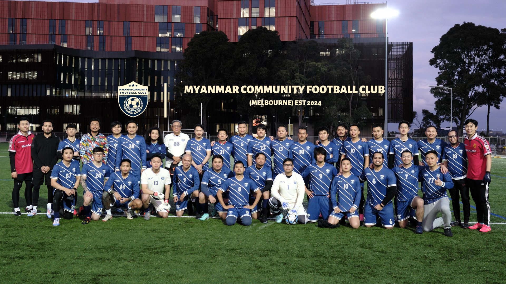 The full MCFC squad in blue striped shirts, posed on the pitch at dusk