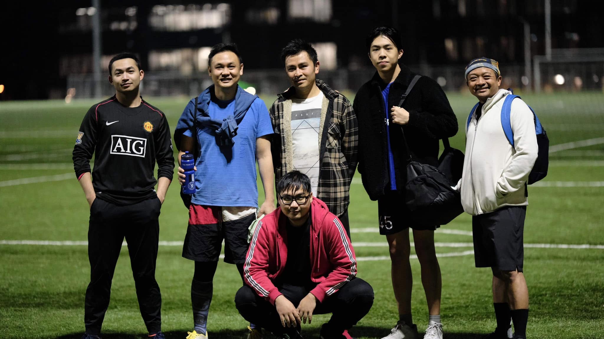 Six players standing and one crouching on the pitch after the game