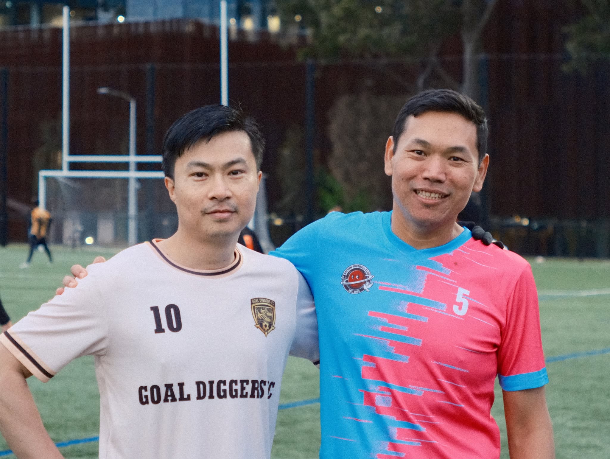 Two players in cream and sky-blue shirts, arms around each other