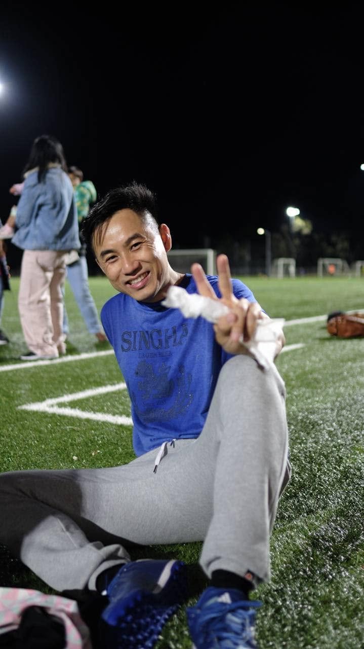 Smiling player sitting on the turf making a peace sign